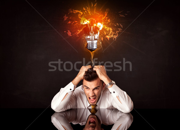 Businessman sitting under a blowing idea bulb Stock photo © ra2studio