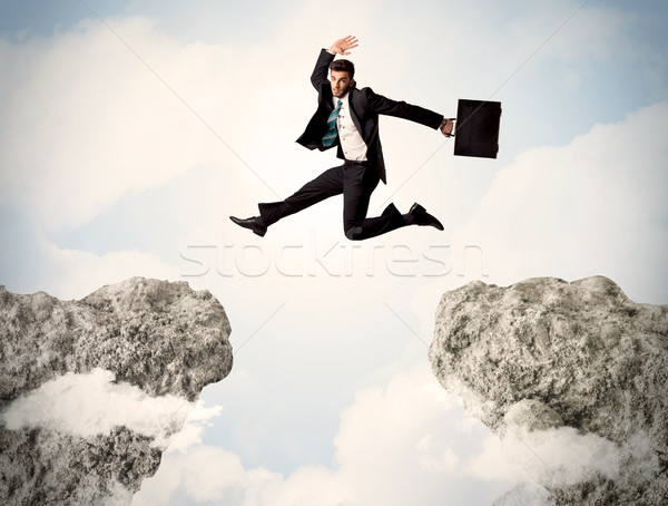 Heureux homme d'affaires sautant falaise homme montagne Photo stock © ra2studio