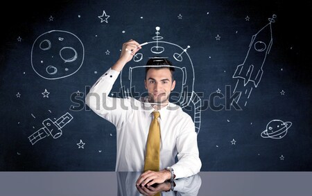 Sales person drawing helmet and space rocket Stock photo © ra2studio