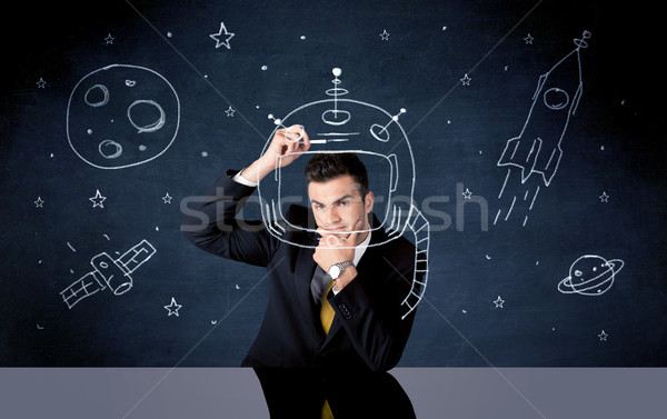 Sales person drawing helmet and space rocket Stock photo © ra2studio