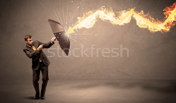 Business man defending himself from a fire arrow with an umbrell Stock photo © ra2studio