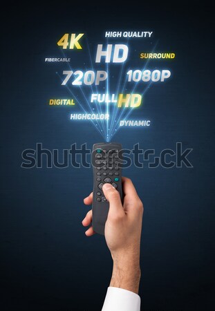 Hand with remote control and multimedia properties Stock photo © ra2studio