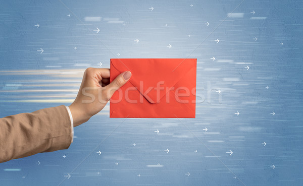 Hand holding envelope with arrows around Stock photo © ra2studio