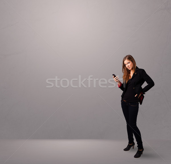 young lady standing and holding a phone with copy space Stock photo © ra2studio