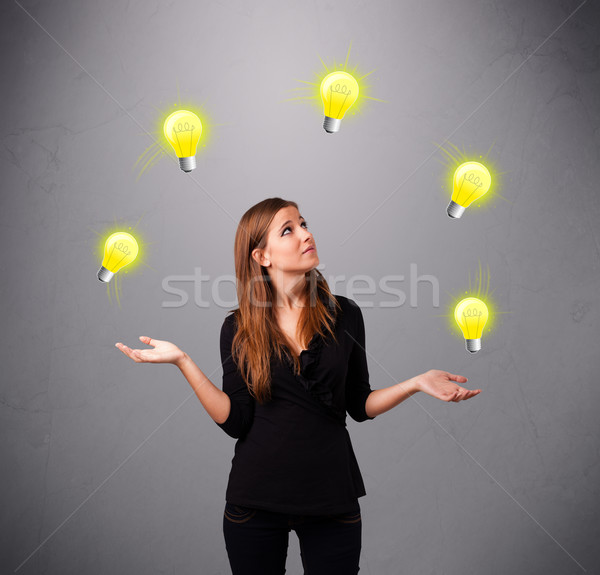 young lady standing and juggling with light bulbs Stock photo © ra2studio