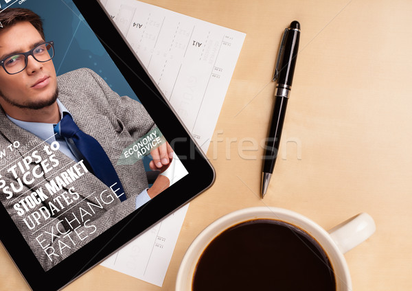 Workplace with tablet pc showing magazine cover and a cup of coffee on a wooden work table closeup Stock photo © ra2studio