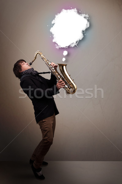 Young man playing on saxophone with copy space in white cloud Stock photo © ra2studio