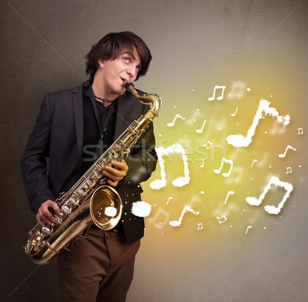 Handsome musician playing on saxophone with musical notes Stock photo © ra2studio