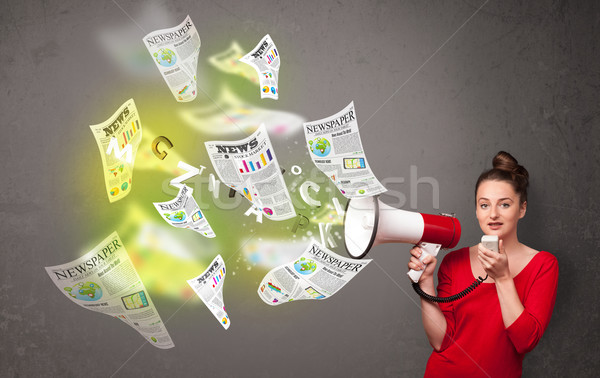 Girl yelling into loudspeaker and newspapers fly out Stock photo © ra2studio