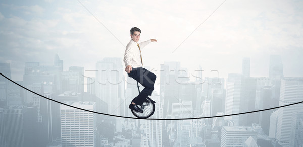 Braver Guy équitation corde au-dessus cityscape Photo stock © ra2studio