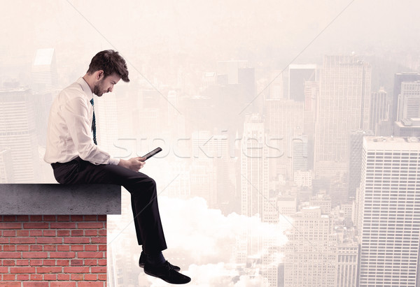 Office worker sitting on rooftop in city Stock photo © ra2studio