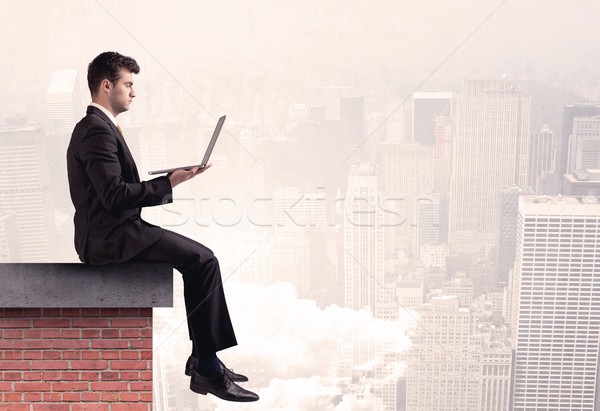 Office worker sitting on rooftop in city Stock photo © ra2studio