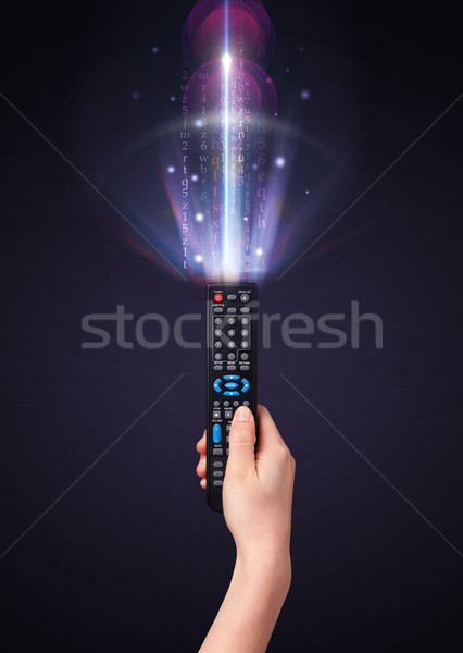 Hand with remote control and shining numbers Stock photo © ra2studio