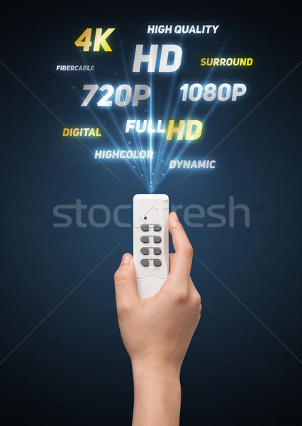 Hand with remote control and multimedia properties Stock photo © ra2studio