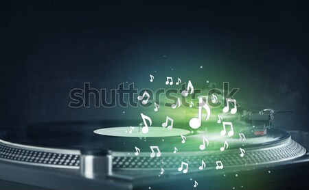 Stock photo: Turntable playing music with audio notes glowing