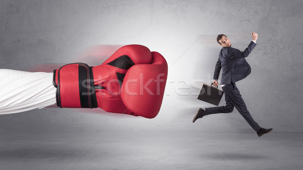 Businessman gets a hit from a giant hand Stock photo © ra2studio