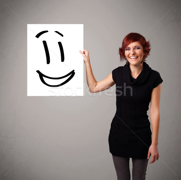 Young woman holding smiley face drawing Stock photo © ra2studio