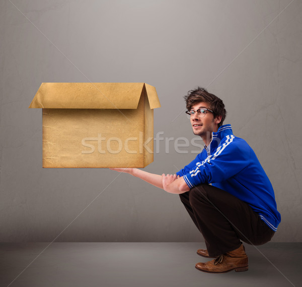 Goog-looking man holding an empty brown cardboard box Stock photo © ra2studio