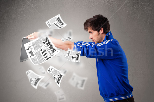 Young man holding a laptop and reading the explosive news Stock photo © ra2studio
