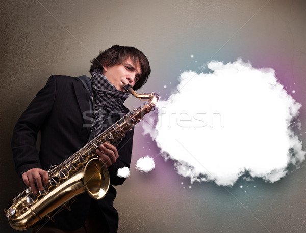 Young man playing on saxophone with copy space in white cloud Stock photo © ra2studio