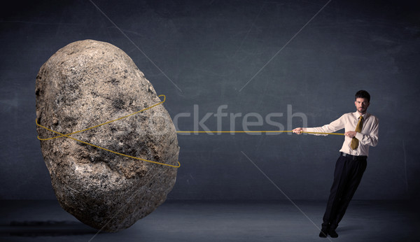 Businessman pulling huge rock with a rope  Stock photo © ra2studio