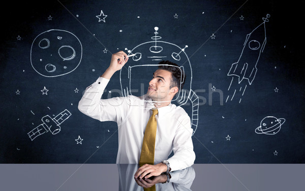 Sales person drawing helmet and space rocket Stock photo © ra2studio