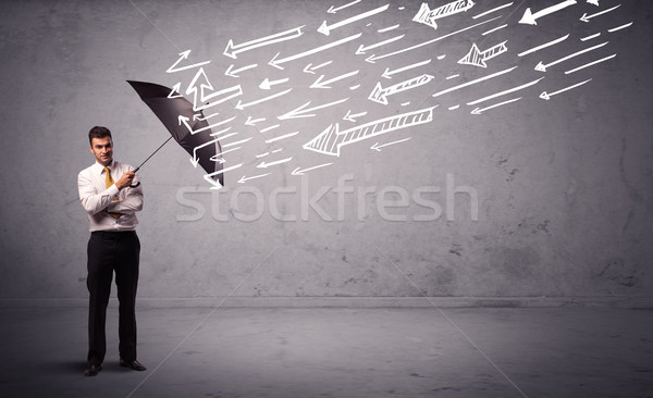 Business man standing with umbrella and drawn arrows hitting him Stock photo © ra2studio