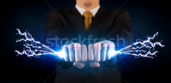 Business person holding electrical powered wires Stock photo © ra2studio