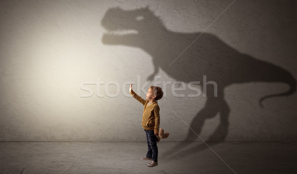Stock photo: Dinosaurus shadow behind cute boy