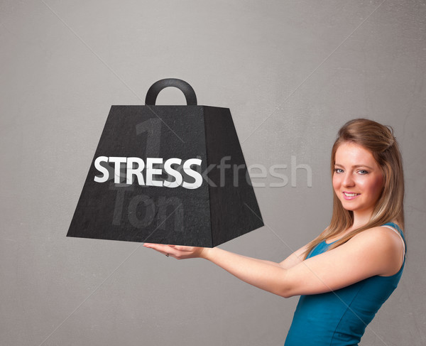 Stock photo: Young woman holding one ton of stress weight
