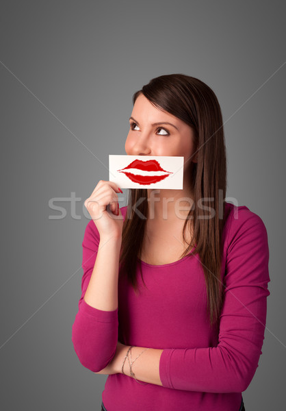 Happy pretty woman holding card with kiss lipstick mark Stock photo © ra2studio