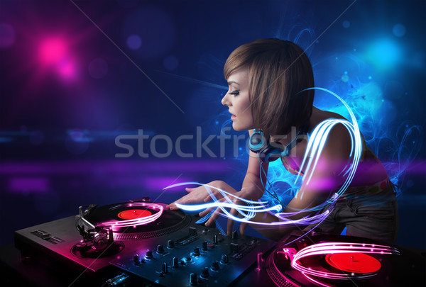 Disc jockey playing music with electro light effects and lights Stock photo © ra2studio