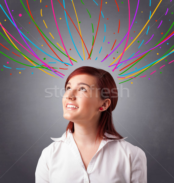 Young girl thinking with colorful abstract lines overhead Stock photo © ra2studio