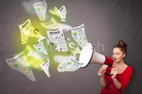 Girl yelling into loudspeaker and newspapers fly out Stock photo © ra2studio