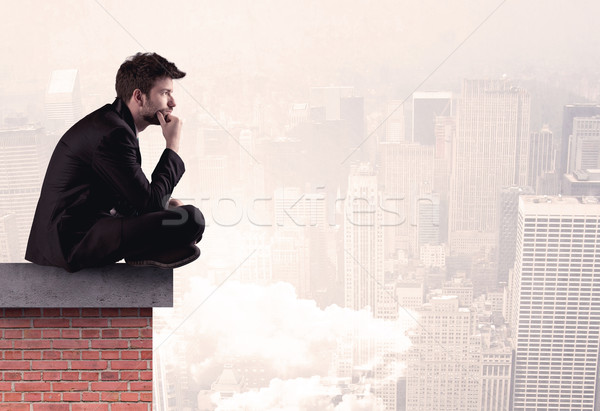 Office worker sitting on rooftop in city Stock photo © ra2studio