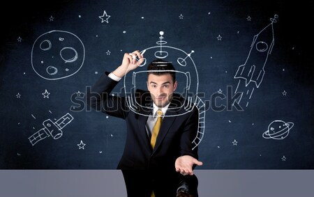 Sales person drawing helmet and space rocket Stock photo © ra2studio