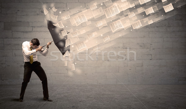 Business man protecting with umbrella against wind of papers Stock photo © ra2studio