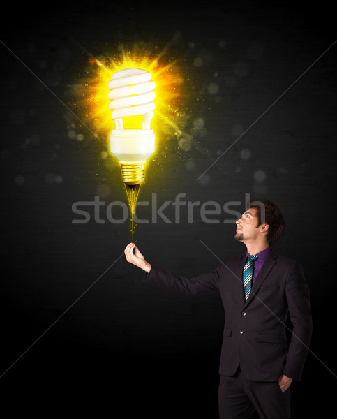Businessman with an eco-friendly bulb Stock photo © ra2studio