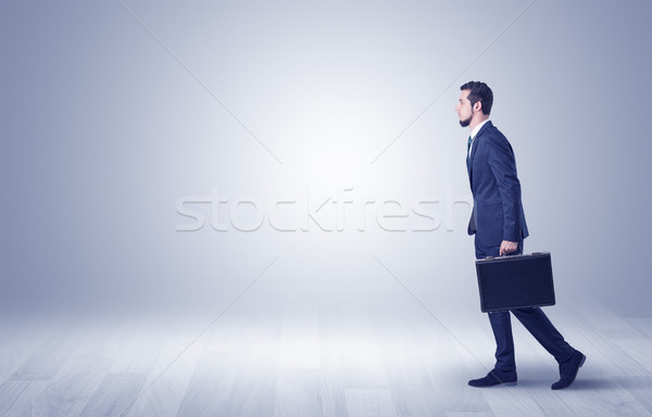 Businessman walking in front of an empty wall Stock photo © ra2studio