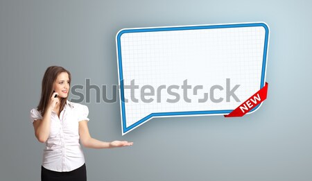 Stock photo: Beautiful young woman standing next to a modern speech bubble copy space and making phone call