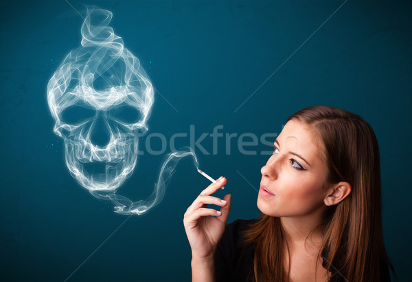 Young woman smoking dangerous cigarette with toxic skull smoke  Stock photo © ra2studio