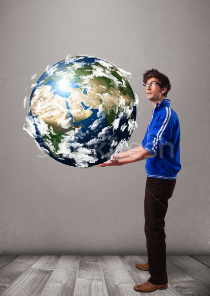 Good-looking man holding 3d planet earth Stock photo © ra2studio
