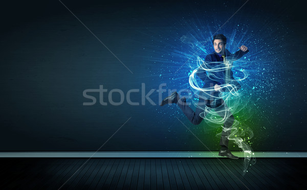 Talented cheerful businessman jumping with glowing energy lines Stock photo © ra2studio