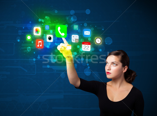 Young businesswoman pressing colorful mobile app icons with boke Stock photo © ra2studio