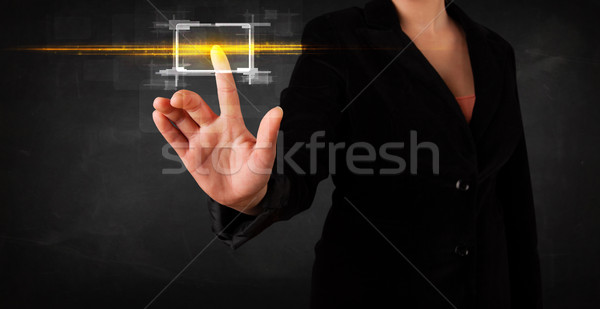 Young tech lady touching button with orange light beams concept Stock photo © ra2studio