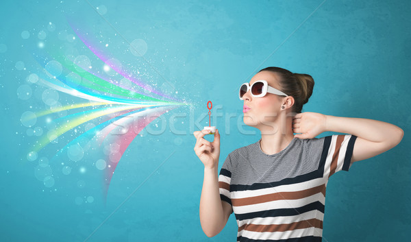 Stock photo: Beautiful girl blowing abstract colorful bubbles and lines