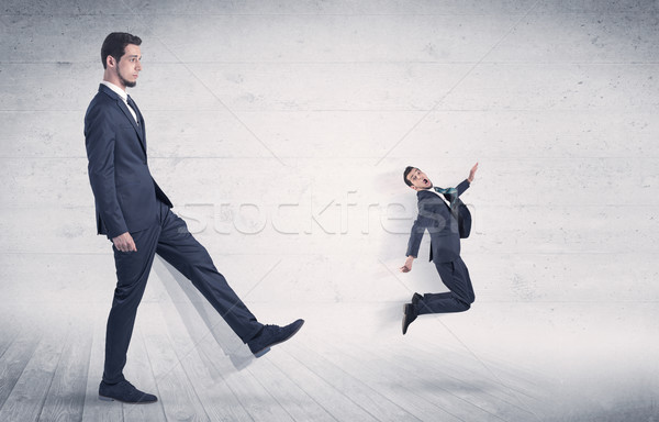 Big man kicking small man with grungy background Stock photo © ra2studio