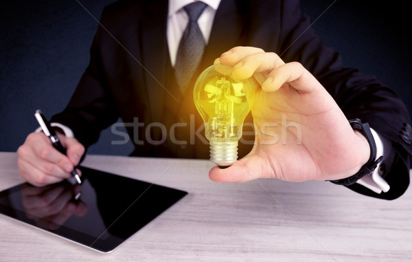 man in suit holding a glowing yellow light bulb Stock photo © ra2studio