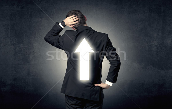 Young businessman standing with arrow on his back Stock photo © ra2studio