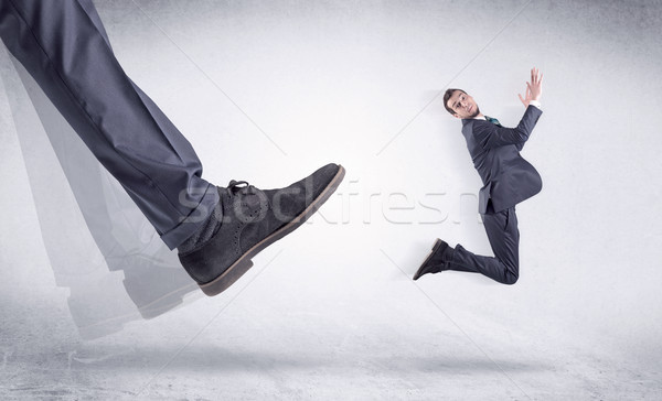 Black shoe kicking small man Stock photo © ra2studio
